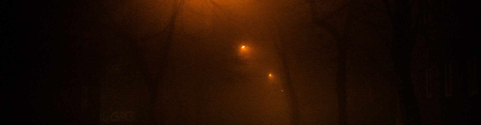 Droga we mgle oświetlona 3 latarniami